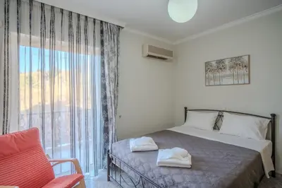 a bedroom with a bed and a large window at Elysian Bayview Souda Bay Panorama Chania in Zakhariás