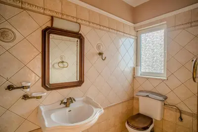 a bathroom with a sink and a toilet and a mirror at Elysian Bayview Souda Bay Panorama Chania in Zakhariás