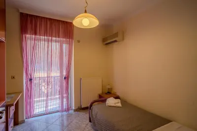 a bedroom with a bed and a large window at Elysian Bayview Souda Bay Panorama Chania in Zakhariás
