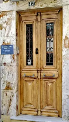a wooden door on a building with a sign on it at Castle Inn in Chania Town