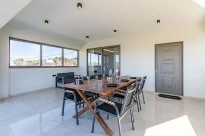 a dining room with a wooden table and chairs at Neaira Apartments in Vatólakkos