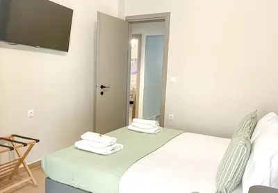 a bedroom with a bed and a mirror at CASA 7 urban 3 bedroom apartment in Chania Town