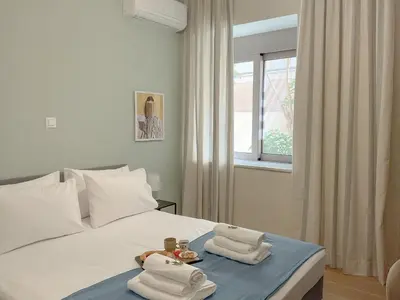 a bedroom with a bed with towels and a window at CASA 7 urban 3 bedroom apartment in Chania Town
