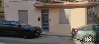 two cars parked in a parking lot in front of a house at CASA 7 urban 3 bedroom apartment in Chania Town