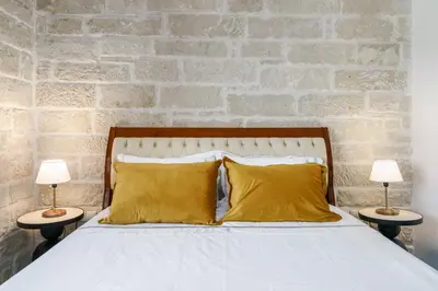 a bedroom with a bed with yellow pillows and two lamps at New Beachfront villa Six Stars in Chania,close to the beach & amenities in Kamisianá