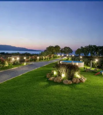 a garden with lights on the grass at night at New Beachfront villa Six Stars in Chania,close to the beach & amenities in Kamisianá