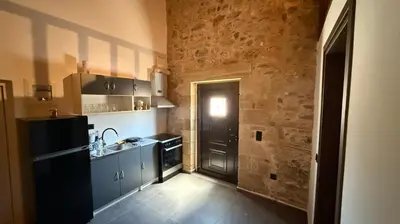 a kitchen with a black door and a black refrigerator at Stone House Experience in Voúvai