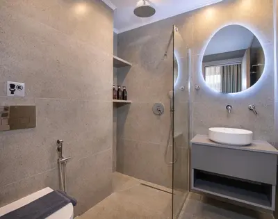 a bathroom with a shower with a sink and a mirror at Alba Boutique Hotel in Chania Town