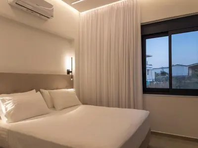 a bedroom with a white bed and a window at Luna Luxury Living in Tavronitis