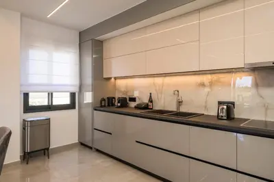 a kitchen with white cabinets and a sink at Luna Luxury Living in Tavronitis