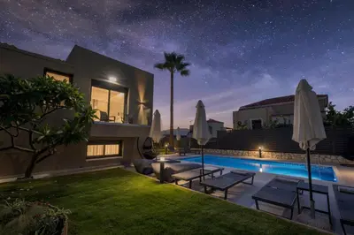 a villa with a swimming pool at night at Luna Luxury Living in Tavronitis