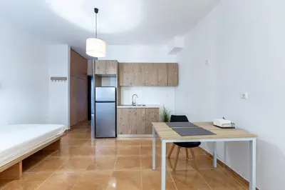 a kitchen and dining room with a table and a refrigerator at Kalamaki del mar apartments in Galatás