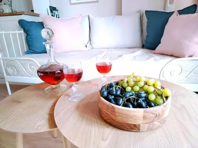 a table with two glasses of wine and a bowl of grapes at RosaMaria's Garden in Kounoupidhianá