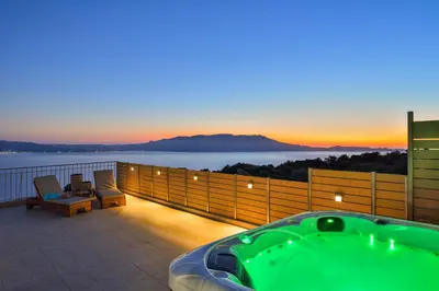 a hot tub on a balcony with a view of the ocean at Villa Ravdoucha in Ravdhoúkha