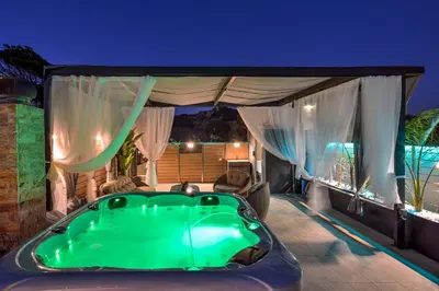 a jacuzzi tub in a backyard at night at Villa Ravdoucha in Ravdhoúkha