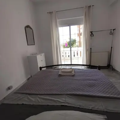 a large bed in a white room with a window at Stylish summer flat, close to beach in Daratso