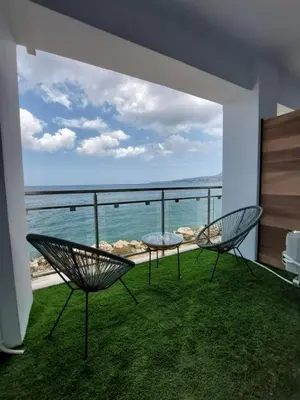 a balcony with two chairs and a view of the ocean at Chavalon Apartments in Kalyves