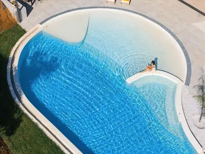 an overhead view of a woman swimming in a swimming pool at Salisol Villa - Green Oasis in Chania Town