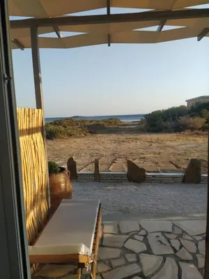 a patio with a chair and a view of the beach at A to Z in Palaiochóra