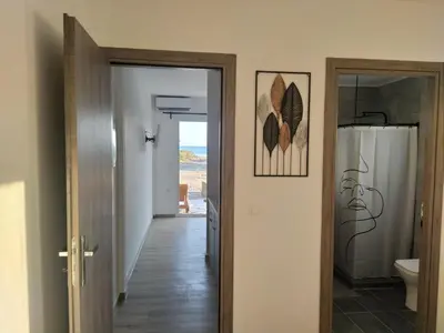 a hallway with a bathroom with a shower and a toilet at A to Z in Palaiochóra