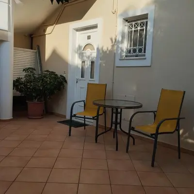 a table and chairs sitting on a patio at Hillside Escape by the Sea in Daratso