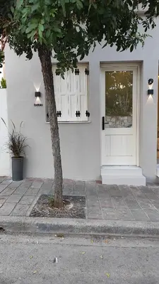 a house with a white door and a tree at Dabia Escape in Chania Old Town in Chania Town