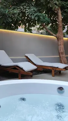 a pool with two lounge chairs next to a tree at Dimora Cozy Retreat in Chania Old Town in Chania Town