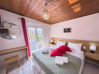a bedroom with a bed with red pillows and a television at Suites Near Elafonisi in Élos
