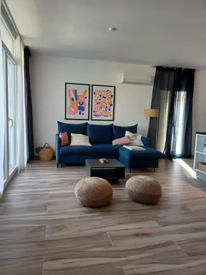 a living room with a blue couch and wooden floors at Wave Loft in Chania Town