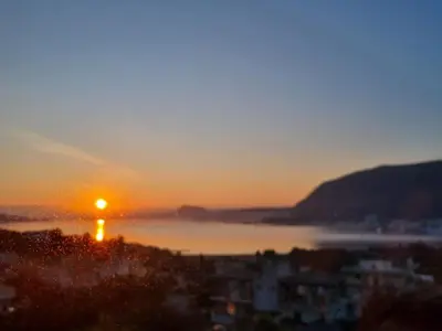 a sunset over a body of water with a city at Wave Loft in Chania Town