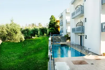 a swimming pool in a yard next to a building at Popi Hotel Apartments in Agia Marina Nea Kydonias