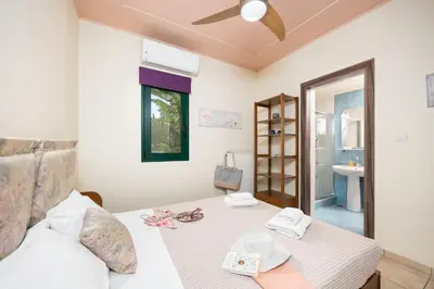 a bedroom with a bed with a table and a mirror at Aloni Villa in Káïna