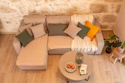 a couch with pillows and a table in a living room at Anamniseis Giorgio Falasarna in Plátanos