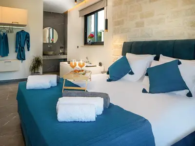a large bed with two pillows and a table on it at PanStel Twin Villas with private pools and jacuzzi in Ayiá