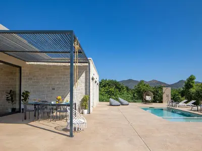 a patio with a table and chairs next to a pool at PanStel Twin Villas with private pools and jacuzzi in Ayiá