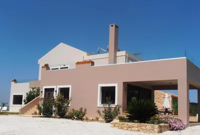 a house on the beach with a blue sky at Villa Lofos in Perivólia
