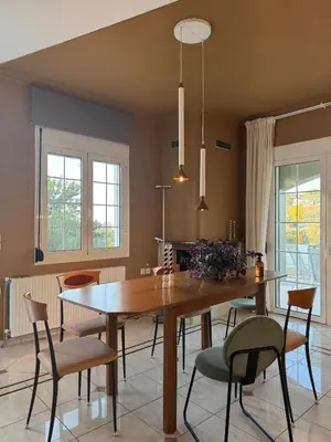 a dining room with a wooden table and chairs at Nature spacious apt, 2km from Chania old town, private parking in Chania Town