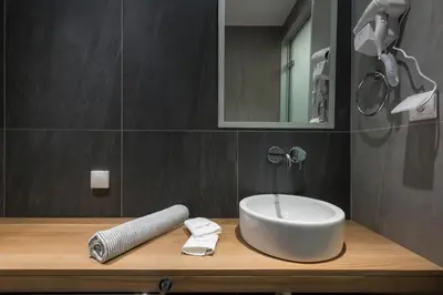 a bathroom with a white sink and a mirror at Mirma City apartment2 Old Town in Chania Town