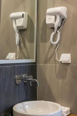 a bathroom with a white hair dryer and a mirror at Mirma City apartment2 Old Town in Chania Town
