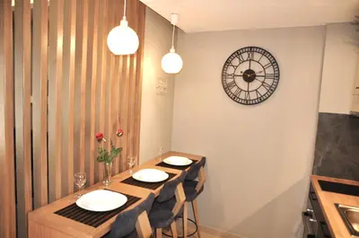a dining room with a table and a clock on the wall at Mirma City apartment2 Old Town in Chania Town