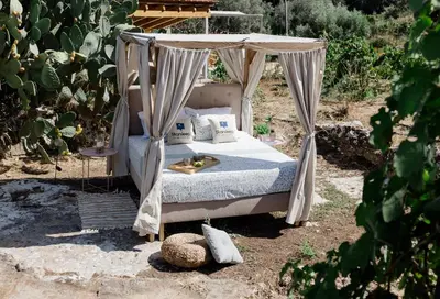 a bed with a canopy in a garden at Star Sleep Dourakis Winery Chania in Alikampos