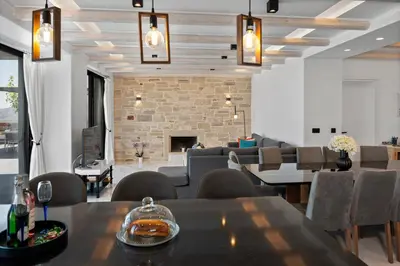 a dining room with tables and chairs and a fireplace at Villa Grand Fysaeri in Vamos