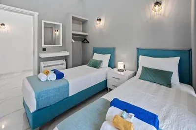 two beds in a bedroom with blue and white at Villa Grand Fysaeri in Vamos