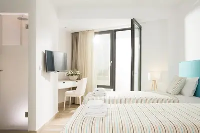 a bedroom with a bed and a desk and a tv at S&K Villas in Kalamaki Chanion