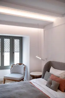 a bedroom with a bed and a chair and a window at Ionas Boutique Hotel in Chania Town