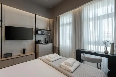 a bedroom with a bed with a television and a desk at Amara Luxury Suites With Private Hot Tub in Chania Town