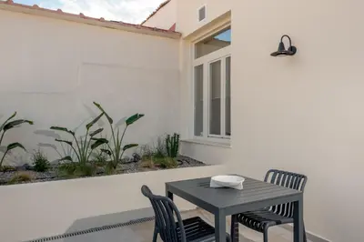 a patio with a table and chairs and a window at Amara Luxury Suites With Private Hot Tub in Chania Town