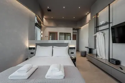 a bedroom with a large bed with two white towels at Amara Luxury Suites With Private Hot Tub in Chania Town
