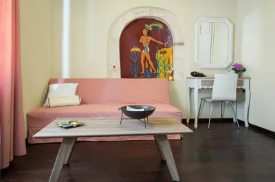 a living room with a pink couch and a table at Casa Di Porto in Chania Town