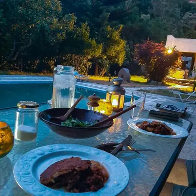 a table with plates of food on it next to a pool at Elafonisi Manor with Private Pool & Jaccuzi in Perivólia